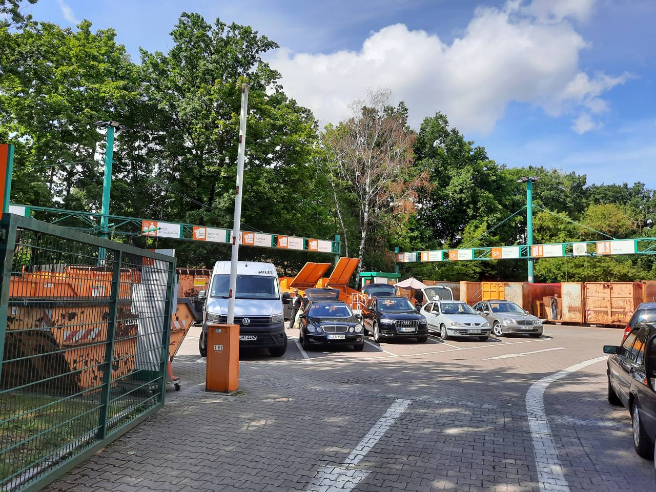 Entrance to a municipal recycling collection point (Recyclinghof) in Berlin, Germany, with signage and collection containers